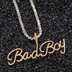 Nahaufnahme des goldenen Bad Boy Buchstaben-Anhängers mit glänzenden Steinen