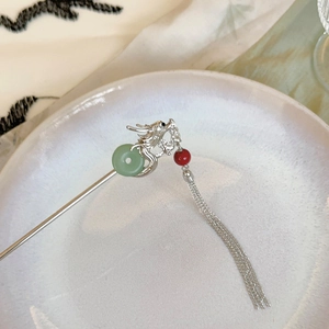 Détail de l'épingle à cheveux dragon argenté avec boucle de jade vert et pompons
