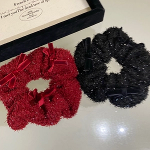 Sparkly red and black plush scrunchies with velvet bows for festive hair styling