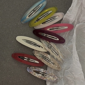 Set of colorful oval acetate hair clips in diverse marble and jelly finishes with metal grips