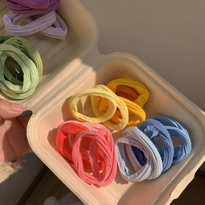Lot de 5 chouchous élastiques aux couleurs macaron présentés dans un plateau en papier