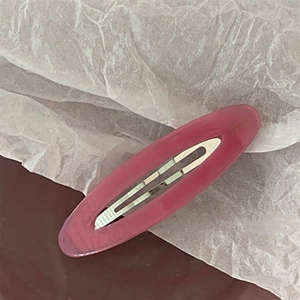 Detailed macro view of magenta acetate oval barrette clip with Barrette La France lettering