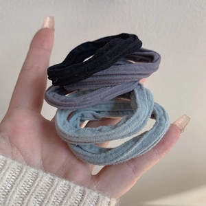 Détail d'élastiques à cheveux en peluche haute élasticité noirs, gris foncé et bleu clair