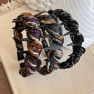 Three knitted non-slip headbands with teeth in black, purple, and green mixed colors
