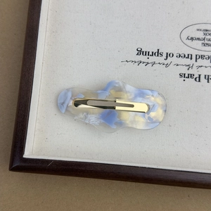 Irregular cloud-shaped acetate hair clip with colorful marble pattern and gold metal base