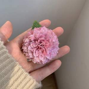 Gros plan détaillé d'une pince à cheveux chrysanthème rose avec des pétales en tissu