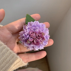Détail de la pince à cheveux chrysanthème violette avec pétales en tissu et feuille