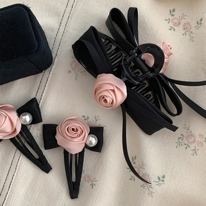Detail showing pink satin roses and faux pearls on black silk ribbon hair clips
