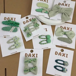 Handmade green floral embroidery bow hair clips set for kids on white display card