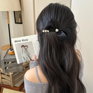 Elegante fermaglio per capelli a fiocco in raso nero con perle a cuore su capelli mossi