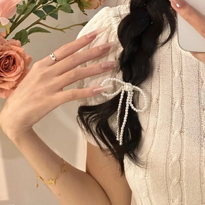 Elegant pearl bow hair clip with luxury gold butterfly bracelet and knit sweater