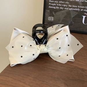 Detail view of French vintage hair claw with cream satin and black polka dot mesh overlay