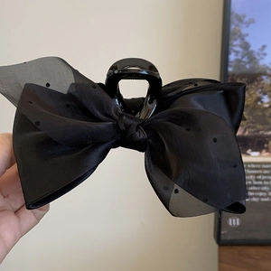 Close-up of elegant black polka dot mesh bow hair claw clip with a glossy finish