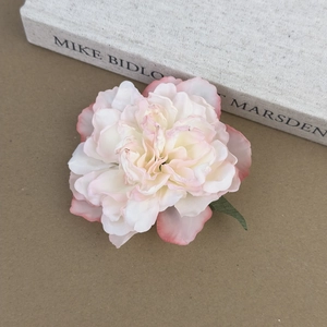Détail macro d'une pince à cheveux pivoine rose et blanche avec pétales en tissu réalistes