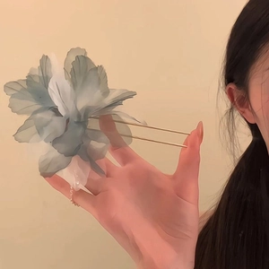 Close-up of a large blue gradient tulle flower hair pin with golden dual-prong forks