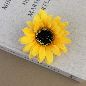 Gros plan d'une pince à cheveux tournesol jaune réaliste en tissu de soie pour les vacances