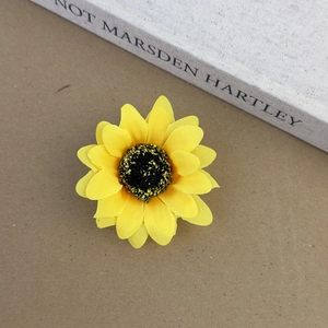 Vue détaillée de dessus d'une barrette tournesol jaune réaliste sur un vieux livre