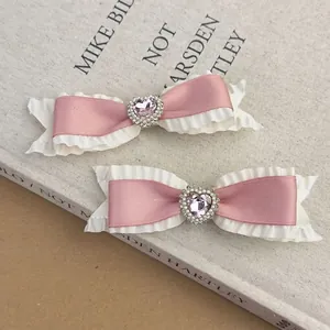 Set of pink satin bow hair clips with white lace, heart rhinestones, and silk finish