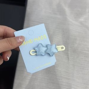 Detailaufnahme hellblauer Stern-Haarklammern mit Glitzer auf einer Designkarte