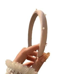 Eleganter aprikosenfarbener Schwamm-Haarreif mit weißen Perlen als stilvolles Haar-Accessoire