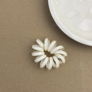 Élastique à cheveux en spirale blanc moderne avec noyau durable sur fond texturé brun
