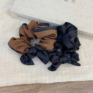 Elegant oversized brown and black bow hair scrunchies with soft satin texture