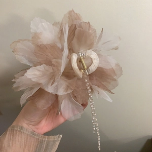 Detail of champagne floral hair claw clip featuring elegant long pearl tassel pendants