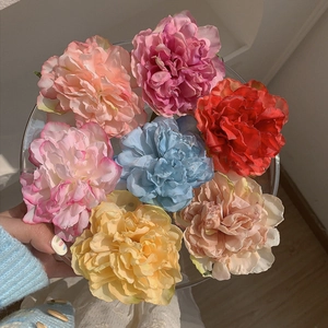 Macro detail of artificial silk peony hair clips in various vibrant floral colors