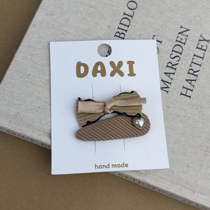 Detail of corduroy bow hair clip and heart pearl teardrop clip on display card