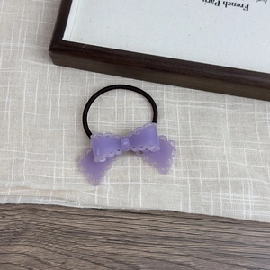 Detailed view of a purple matte bow hair tie with hollow lace edges on high elastic band