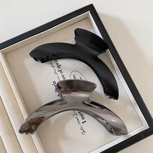 Minimalist large arched hair claws set in matte black and glossy gunmetal finishes