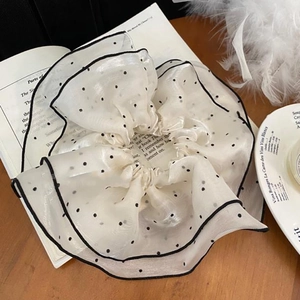 Detail of white organza scrunchie with black polka dots and dark edge piping