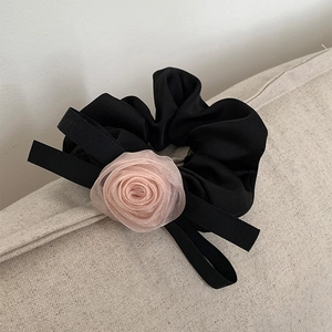 Chouchou rose en tulle style français avec rubans noirs sur fond crème minimaliste
