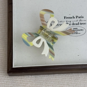 French cream style acetate hair claw clip with colorful stripes and white bow