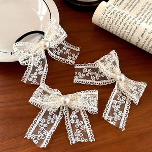 French vintage lace bow hair clip set with pearls on a rustic wooden background