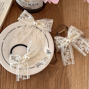 French retro lace bow hair clip with faux pearl on elegant white porcelain plate
