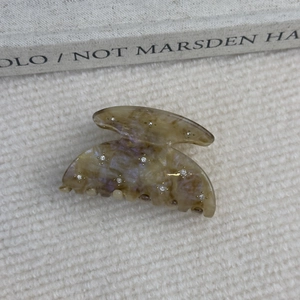 Détail d'une pince à cheveux en acétate à motif écaille avec strass scintillants