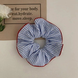 Navy blue and white striped cotton scrunchie with red piping edge on aesthetic backdrop