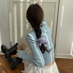 Navy striped scrunchie on hair with blue ribbed long sleeve top and white lace skirt