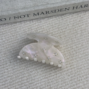 Vue détaillée d'une pince à cheveux en acétate nacré ornée de strass brillants et élégants