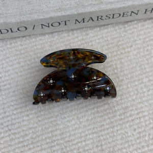 Détail d'une pince à cheveux en acétate écaille de tortue sertie de petits strass fins