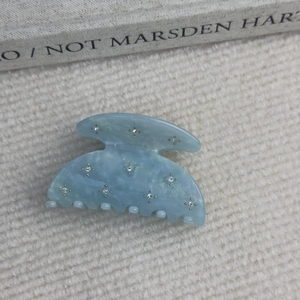 Détail de la pince à cheveux en acétate marbré bleu clair avec strass étincelants