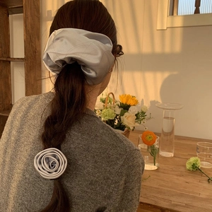 Elegant grey-blue satin scrunchie set with silk flower on a ponytail hairstyle