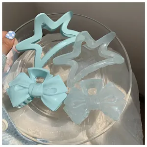 Detail of light blue bow and star hair claws in a glass tray with matte and jelly texture