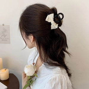 Gros plan détaillé d'une pince à cheveux avec nœud en dentelle portée par un mannequin