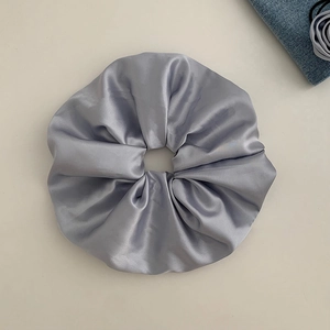 Detail of premium silver-grey satin oversized scrunchie with silky smooth texture