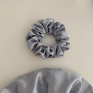 Detail showing the elegant silver-grey satin texture and soft folds of the premium scrunchie set