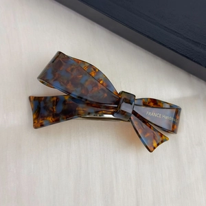 Detailed back view of amber acetate bow hair clip with a secure silver metal spring clasp