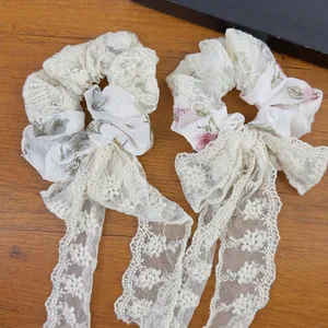 Elegant floral lace scrunchies set with long detachable ribbons on wooden background