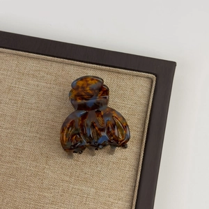 Detail of tortoiseshell acetate claw clip with amber pattern on linen display tray